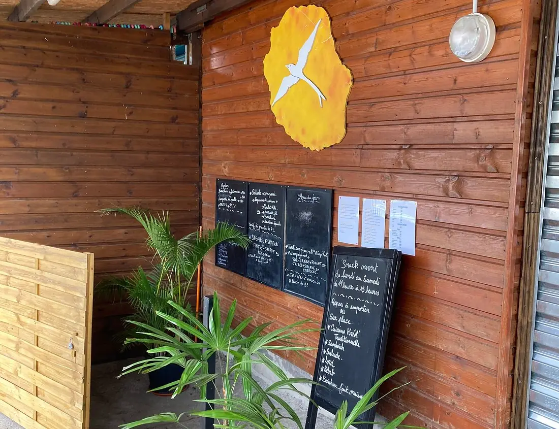 L’entrée du snack : bardage bois, ardoises du menu du jour et enseigne au paille-en-queue